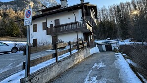 Un bâtiment à deux étages doté d’un balcon, d’une pancarte indiquant qu’il s’agit d’une propriété privée, et avec une montagne en arrière-plan.