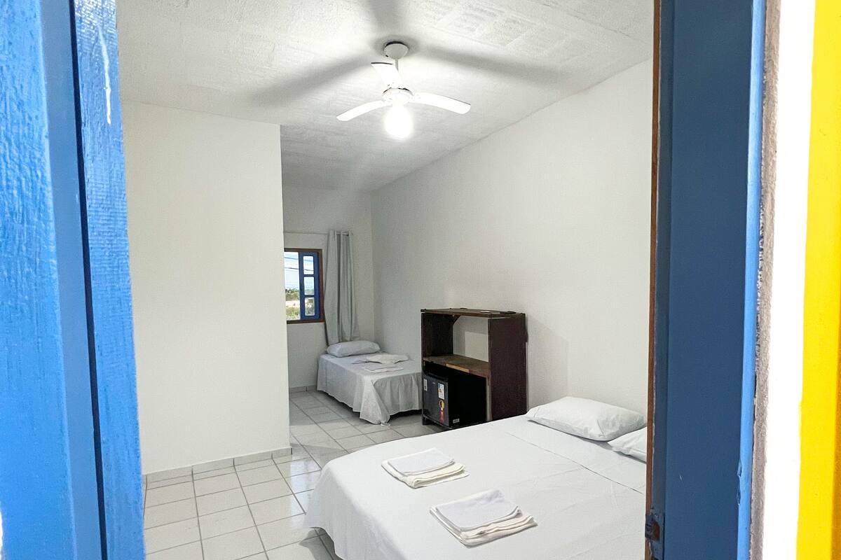 Ein Hotelzimmer mit Bett, Schreibtisch und Deckenventilator.