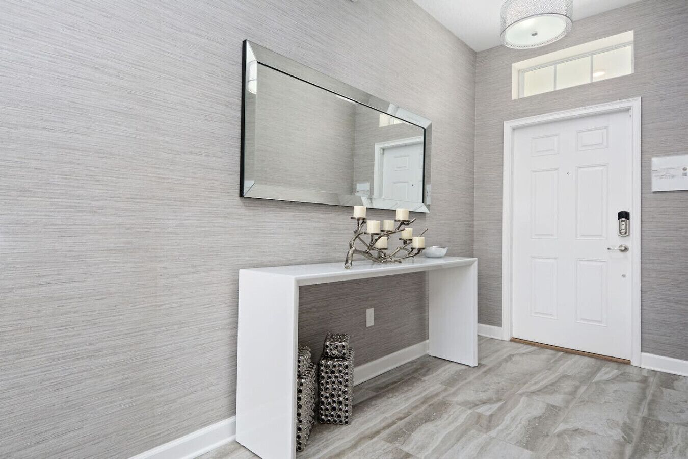 A hallway with a white console table, a mirror, and a door.