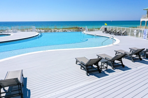 A pool area with lounge chairs and a view of the ocean. - 4BR Split-Level Home with Private Pool + Separate Lower Retreat | Le Zoute (Destin)