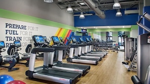 A gym with treadmills, exercise balls, and a motivational wall.