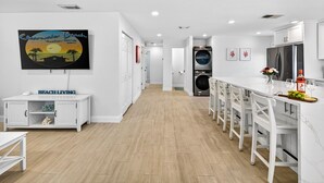 Una cucina moderna con mobili bianchi, forno integrato e frigorifero in acciaio inossidabile.