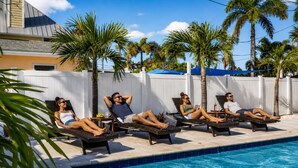 Un'area piscina con lettini e palme.