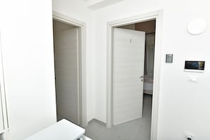 Un couloir avec une porte fermée portant l’inscription « C » et une table blanche.
