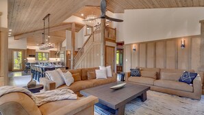A spacious living area with a large sectional sofa, a coffee table, and a staircase leading to an upper level. - Zoe's North Star at Northstar - TLUXP (Northstar)