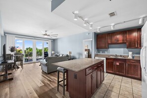 A modern kitchen with dark wood cabinets, a granite countertop, and a dining area with a table and chairs.
