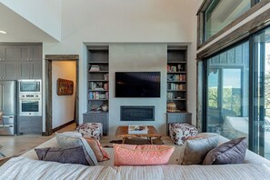 Un salon moderne avec un téléviseur à écran plat, un canapé et une table basse.