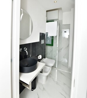 A modern bathroom with a black sink, white toilet, and a glass shower enclosure. - Family Room with private bathroom (San Lazzaro di Savena)