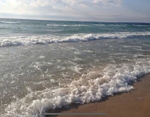 A beach with waves gently lapping onto the shore.
