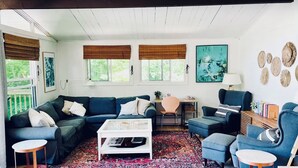A cozy living room with a dark blue sofa, a white coffee table, and a patterned rug.