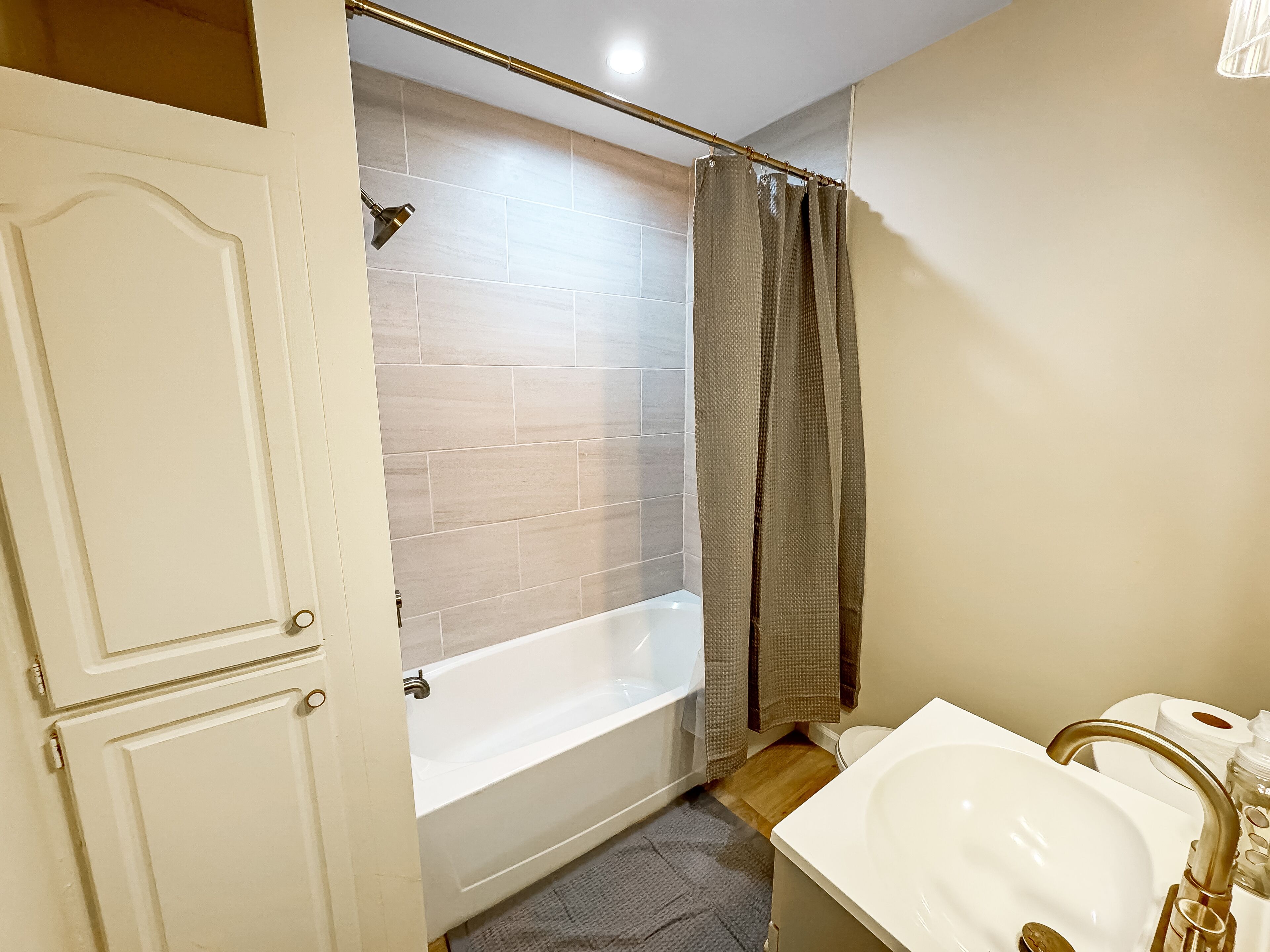 Un baño con bañera, lavamanos y cortina de ducha.