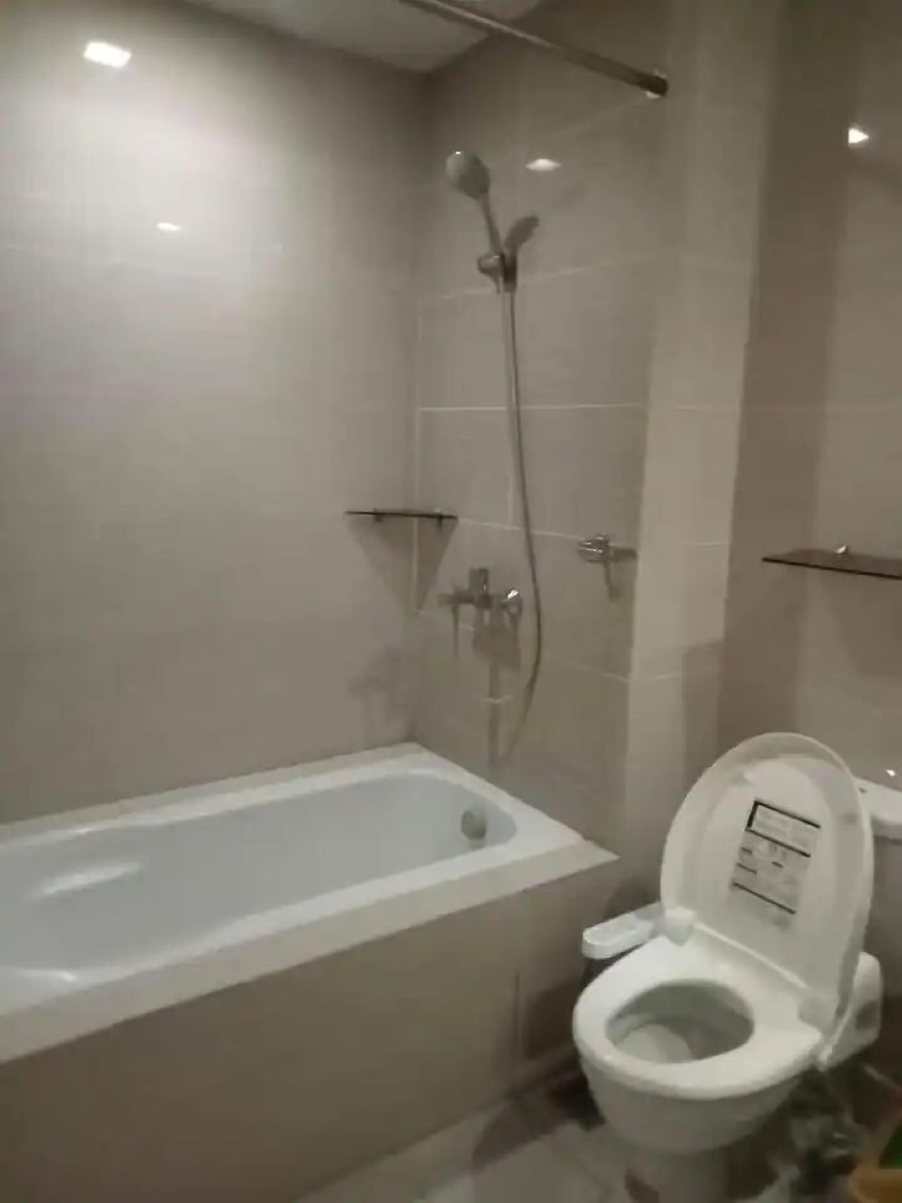 A bathroom with a bathtub, toilet, and shower.
