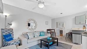 A modern living room with a sofa, coffee table, and a ceiling fan.