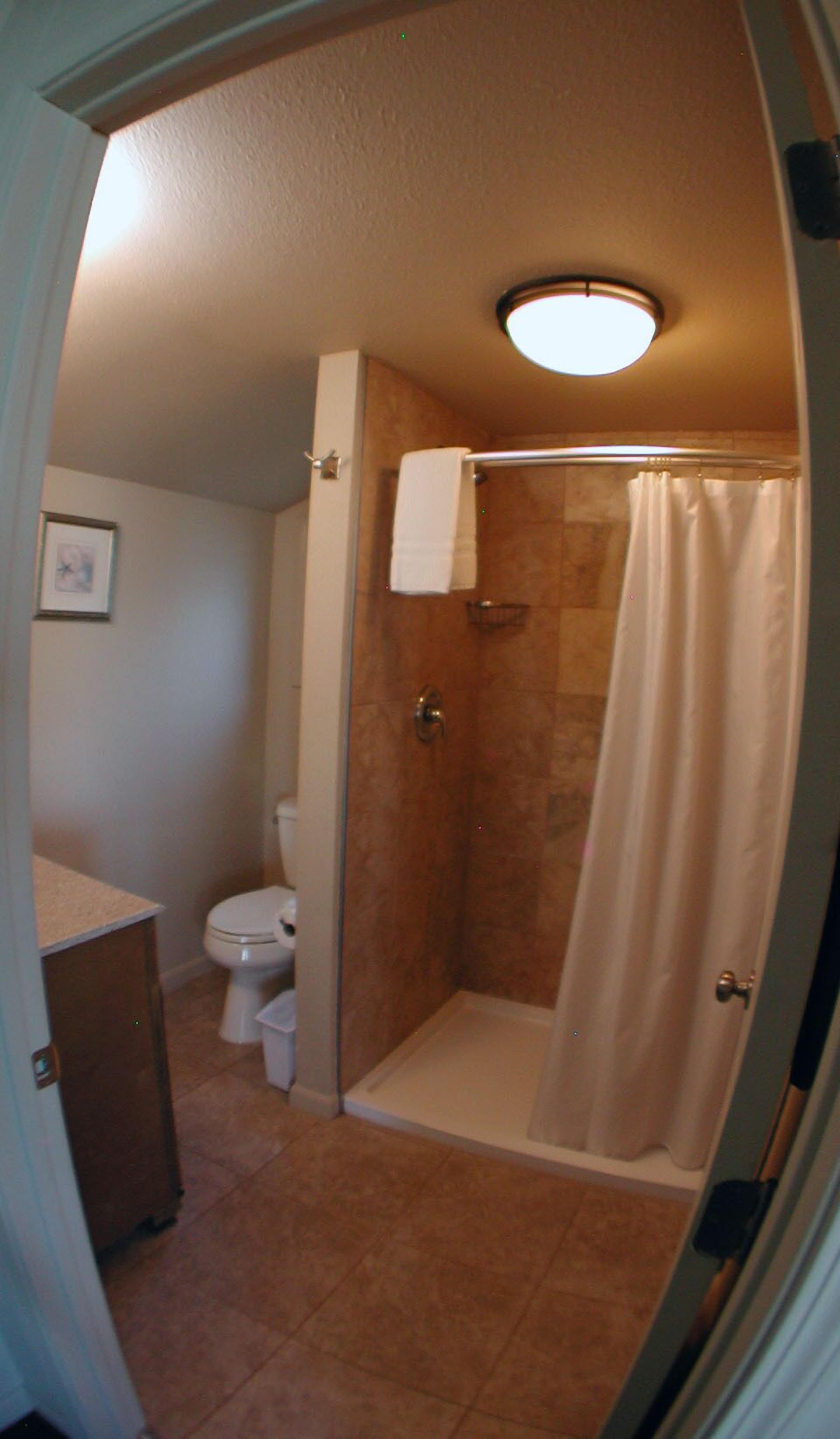 A bathroom with a shower, toilet, and sink.