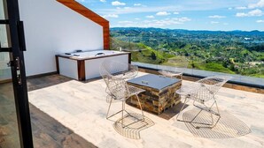 A modern outdoor patio with a stone table and wire mesh chairs, overlooking a scenic landscape. - MONTECIELO 205 TORRE1 (La Ceja)