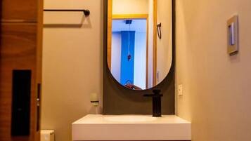 Un bagno con un mobile bagno in legno, uno specchio rotondo e un porta asciugamani.