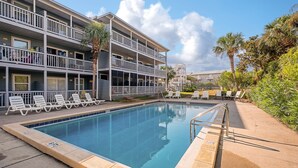 A pool area with lounge chairs and a two-story building with balconies. - KC Coastal 30A Inlet Beach • POOL • 1st Floor • KING • 2 Minute Walk to Beach (Inlet Beach)