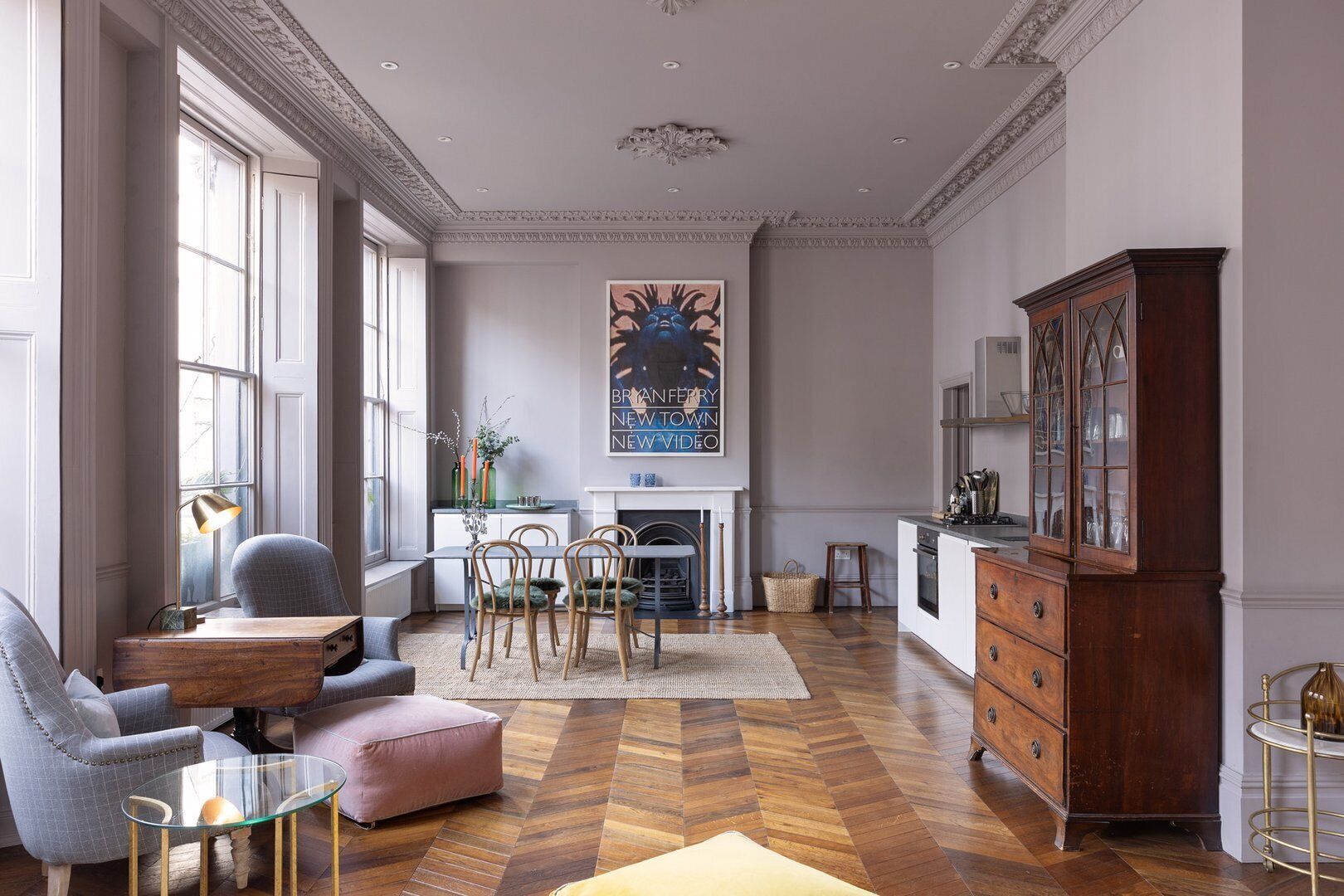 A spacious living room with a fireplace, a dining area, and a kitchen.