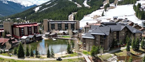 A mountain resort with a lake, buildings, and a ski slope.