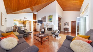 A spacious living room with a fireplace, sofas, and a dining area. - Villa with heatable pool and BBQ in Albufeira (Albufeira)