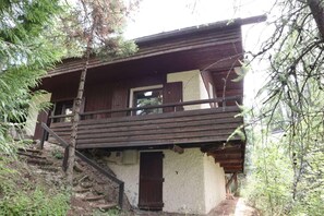 A rustic wooden cabin with a balcony, a staircase leading to the entrance, and a natural surrounding. - Chalet, 10m from ski slopes, view valley, terrace, fireplace or stove, tv, 100m², Les Orres (Les Orres)