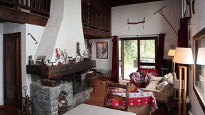 A cozy living room with a stone fireplace, wooden beams, and a comfortable seating area. - Chalet, 200m from shops, view valley, terrace, fireplace or stove, tv, 100m², Les Orres (Les Orres)