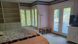 A bedroom with a bed, a small table, a TV, and a sliding glass door. - Wonderful Oasis in Kingston Plantation, near the Embassy and Hilton.  (Myrtle Beach)