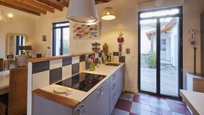 Una cocina con un respingo a cuadros, vigas de madera en el techo, un ventanal y vistas al exterior.