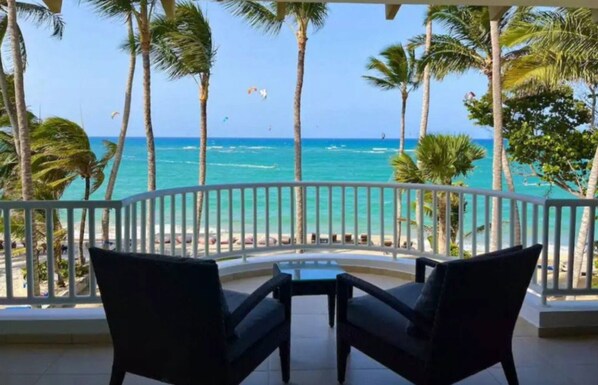Enjoy breathtaking ocean views from this balcony, featuring two comfortable chairs and a small table.