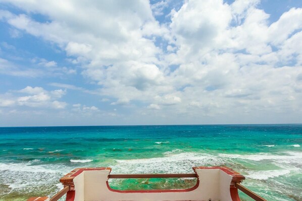 A view from a boat with a clear sky and turquoise sea.