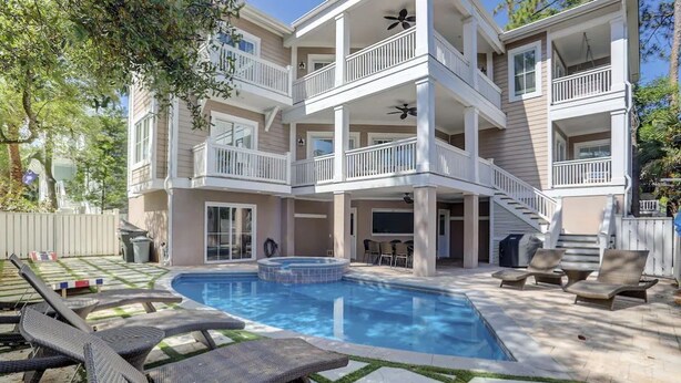 Un edificio de varios pisos con piscina, mobiliario exterior y un patio cubierto.