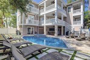 A multi-story building with a swimming pool, outdoor seating, and a covered patio area. - 7 Bayberry - 2nd Row, 6BR/6.5BA, Fully Renovated, Steps from the Beach, Pool (Hilton Head Island)
