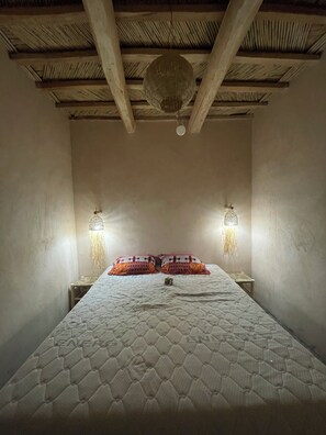 A room with a bed, two wall-mounted lamps, and a hanging light fixture. - Maroc des Merveilles - Chez l'habitant (Ait Sedrate Sahl El Gharbia)