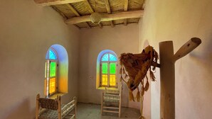 A room with two arched windows, wooden beams on the ceiling, and a ladder. - Maroc des Merveilles - Chez l'habitant (Ait Sedrate Sahl El Gharbia)