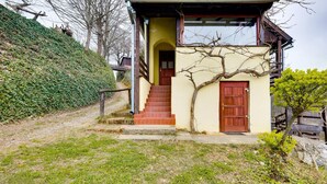 A house with a staircase leading to a wooden door, surrounded by greenery and a hillside. - Lovely home in Veliki Grdevac with WiFi (Veliki Grdevac)