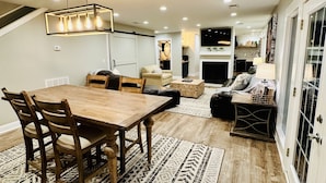 Un salón amplio con una mesa de comedor de madera, asientos cómodos y un ventanal grande.