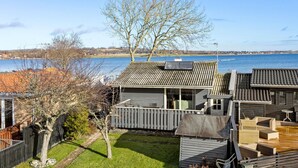 Una propiedad junto al lago con muelle de madera, un edificio pequeño con techo inclinado y vista al lago.