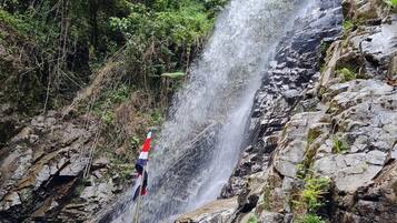 A waterfall cascading over rocky terrain with dense greenery around.