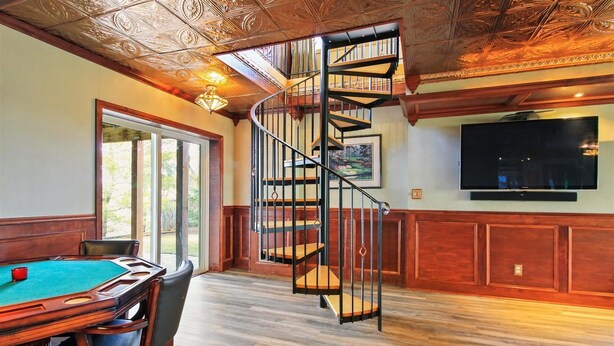 A room with a pool table, a spiral staircase, and a large flat-screen TV mounted on the wall. - Rare Super Host - Arcade w/ 5 Kings, Hot Tub, Pub (Inver Grove Heights)