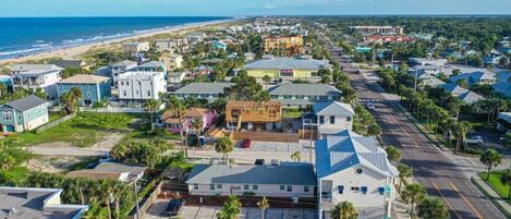 A coastal residential area with houses, a beach, and a clear sky.