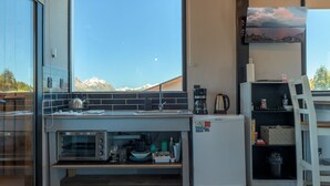 Una cocina moderna con un amplio ventanal, horno empotrado y refrigerador.