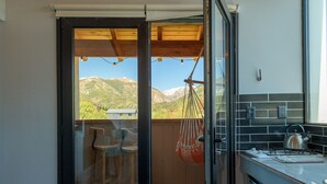 Cocina con vistas a las montañas, una silla colgante y un comedor con sillas.