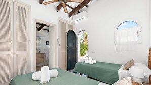 Een hotelkamer met twee bedden, een badkamer en uitzicht op het omliggende landschap.