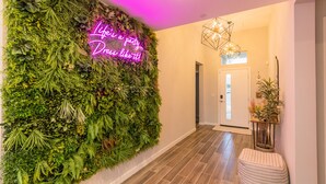 A hallway with a vertical garden wall and a neon sign that reads "Life's a party Dress like it!" - Best views in the desert 15min from DT Palm Springs + 30min from Joshua Tree (Desert Hot Springs)
