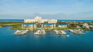 A marina with several multi-story buildings, likely a hotel or resort, with boats docked in the water. - Inlet Marina Villas #524, Nestled between the River & Ocean (New Smyrna Beach)