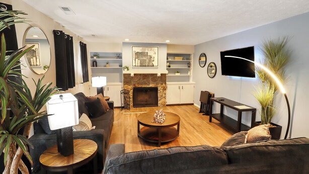 Una sala de estar moderna con chimenea, un sofá, una mesa de centro y un televisor.