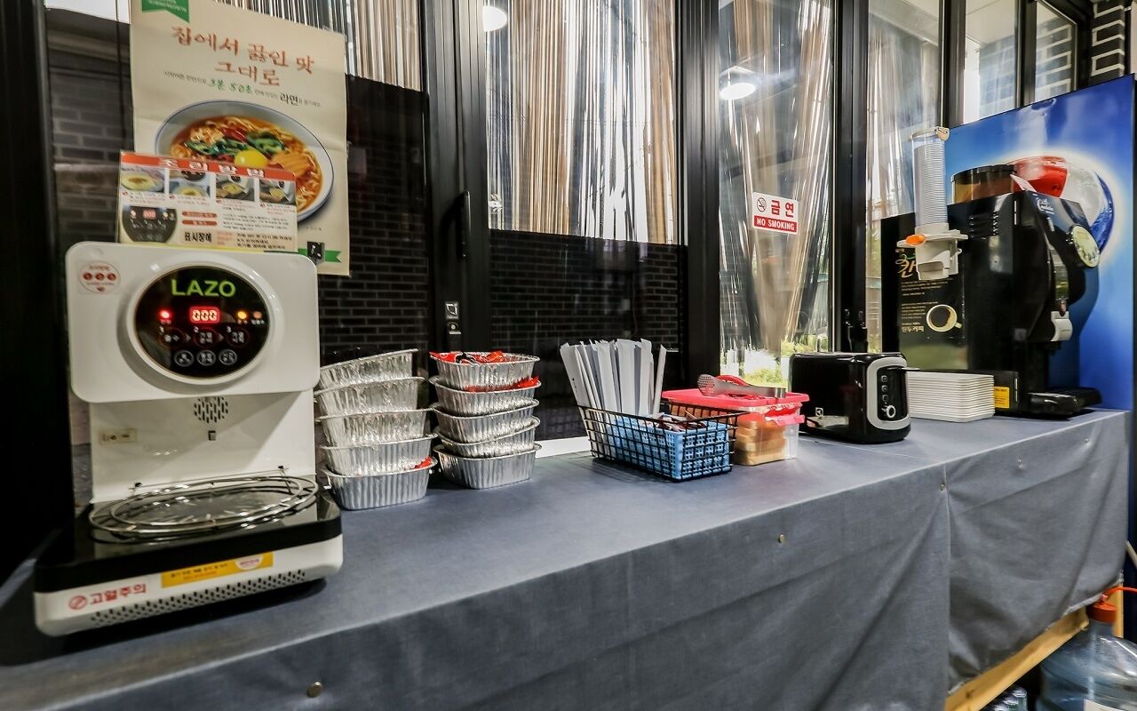 A coffee machine, stacked trays, and a menu on a table.