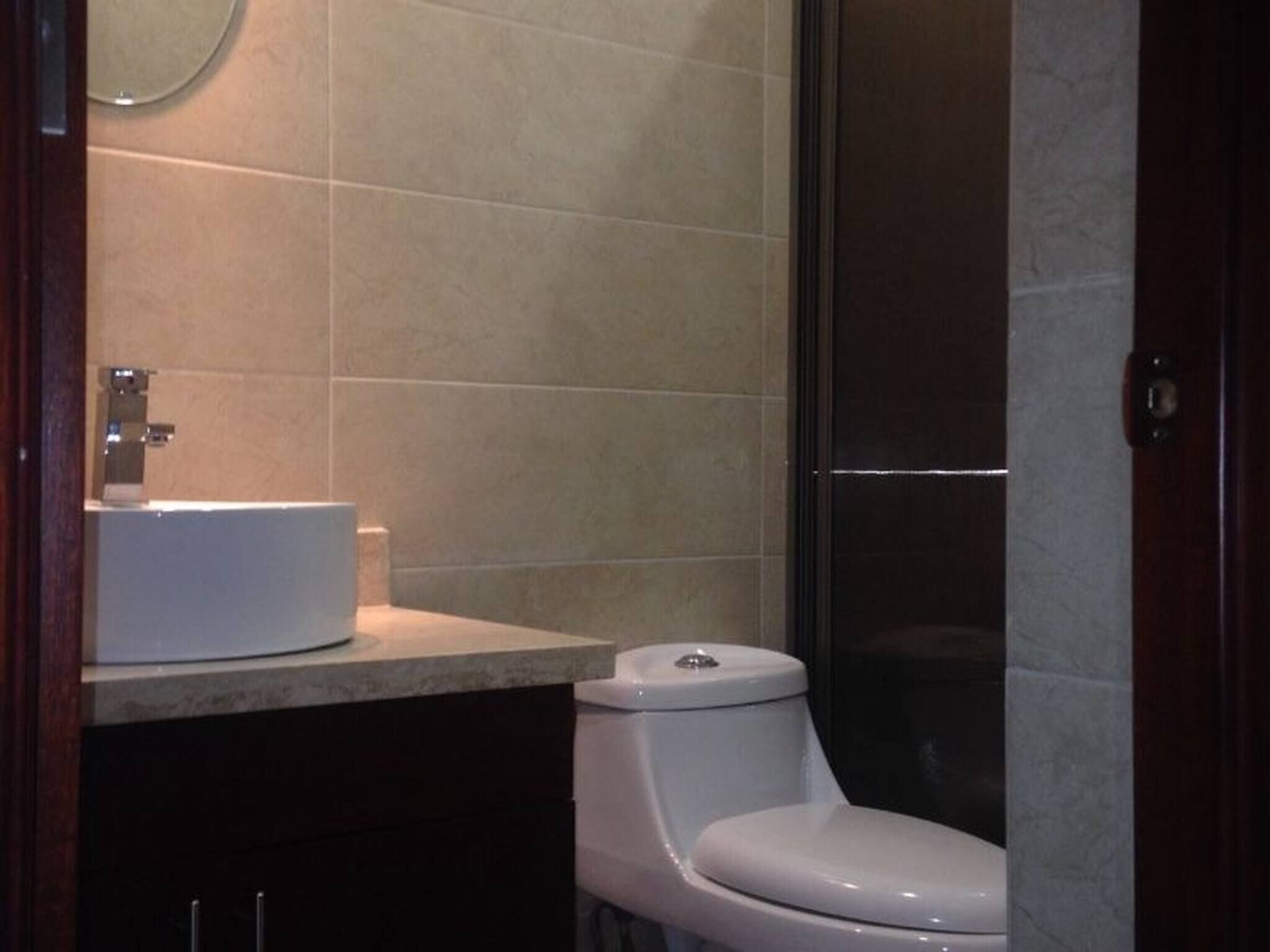 Une salle de bain avec des toilettes, un lavabo et un miroir.