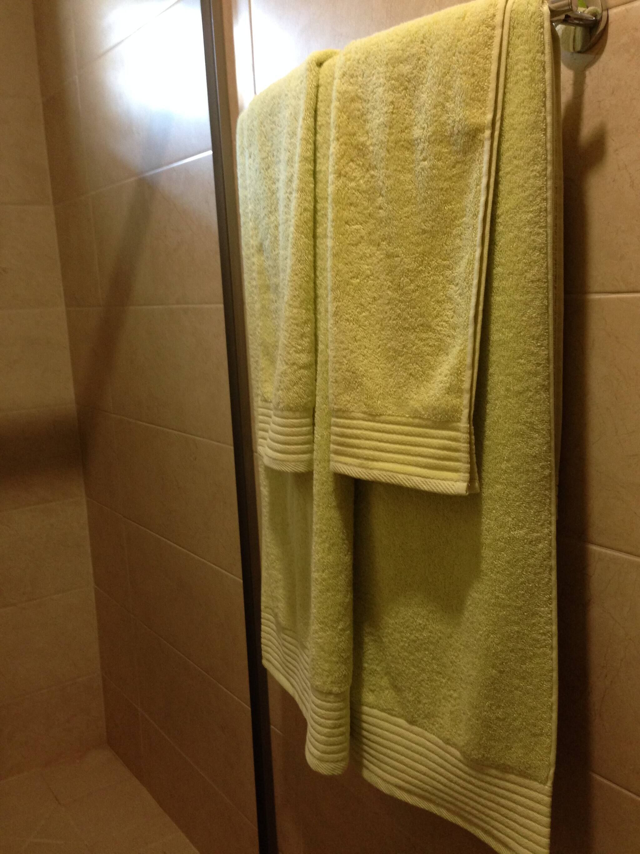 A bathroom with a yellow towel hanging on a towel rack.