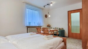 A bedroom with two beds, a wooden desk, a chair, and a door with frosted glass. - Nice apartment in Goslar OT Hahnenklee with WiFi (Goslar OT Hahnenklee)